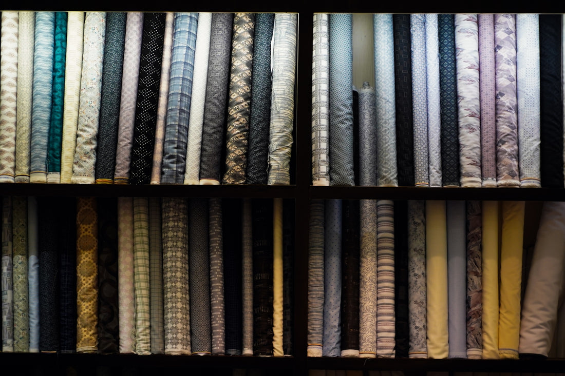 Shelves of rolled fabric with various patterns.