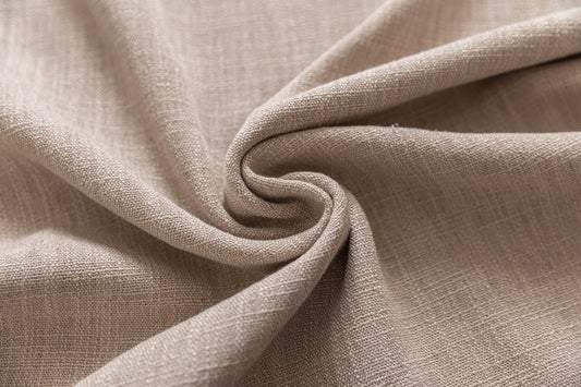 Close-up of beige textured fabric folded into a swirl.