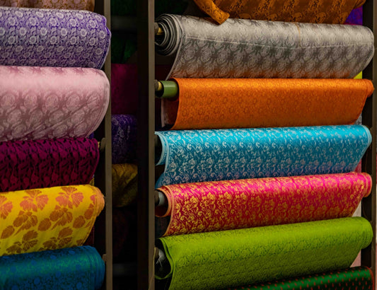 Stacks of colorful patterned fabric rolls on shelves
