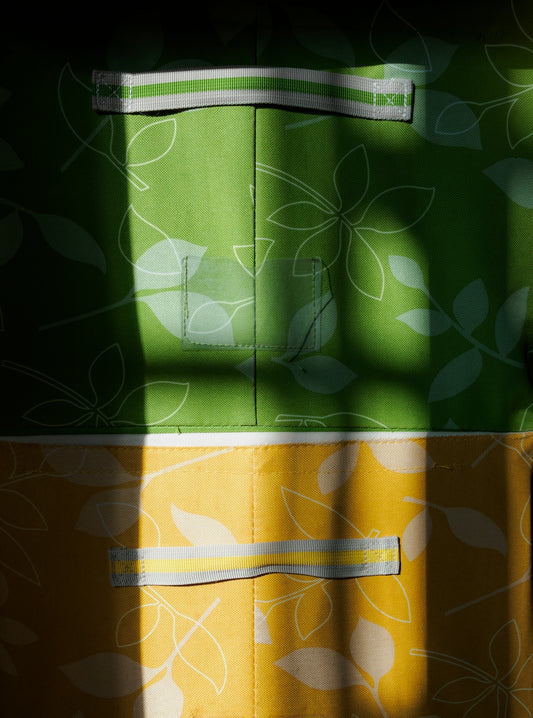 Green and yellow fabric with leaf pattern and shadows.